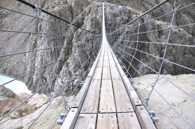 Rope bridge across cliffs clipart