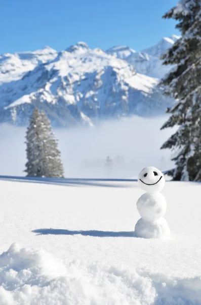 Sneeuwpop tegen Alpine landschap — Stockfoto