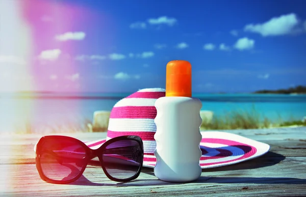 Sombrero, gafas de sol y crema solar — Foto de Stock