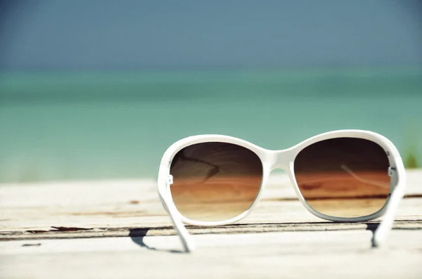 Sunglasses against ocean — Stock Photo, Image