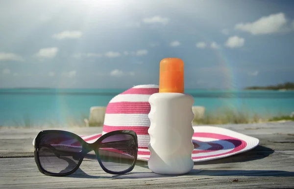 Chapéu, óculos de sol e loção solar — Fotografia de Stock