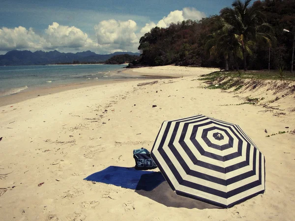 Striped umbrella on a beach — Stock Photo, Image