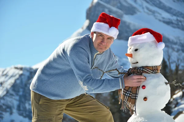 Homem de chapéu de Pai Natal e boneco de neve — Fotografia de Stock