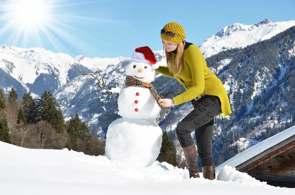 Mädchen dekoriert einen Schneemann — Stockfoto