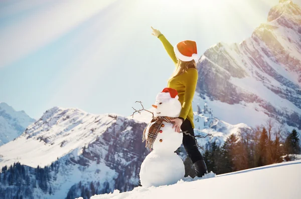 Chica con un muñeco de nieve —  Fotos de Stock