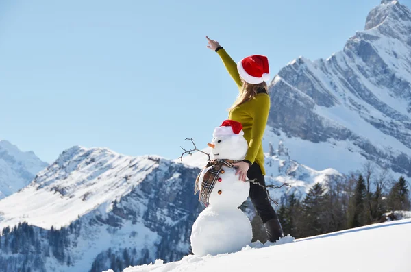 Flicka med en snögubbe — Stockfoto