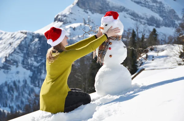 Menina com um boneco de neve — Fotografia de Stock