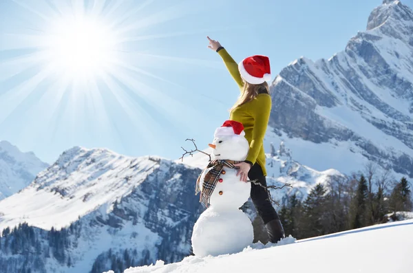 Flicka med en snögubbe — Stockfoto