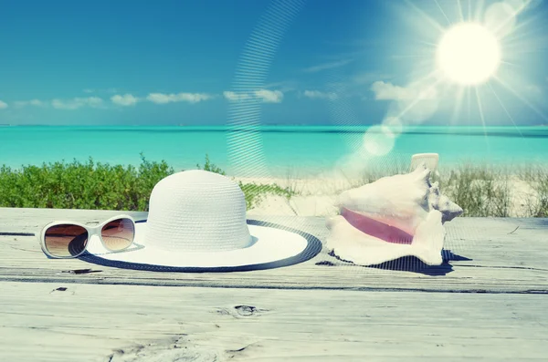 Lunettes de soleil et chapeau sur la plage — Photo