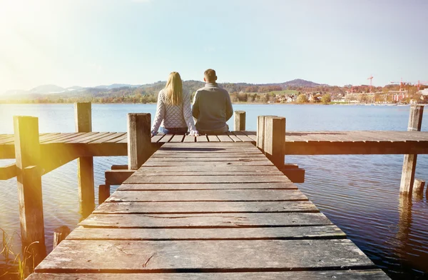 Un couple sur la jetée en bois au bord d'un lac — Photo