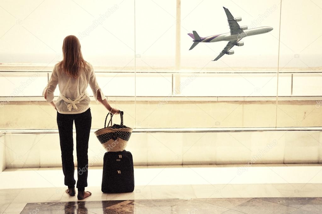 Girl at the airport window looking to the ocean -- retro filtere