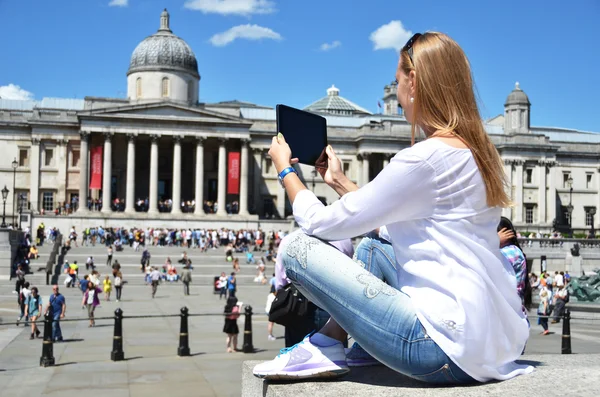 ロンドンのトラファルガー広場でタブレットを持つ少女 — ストック写真