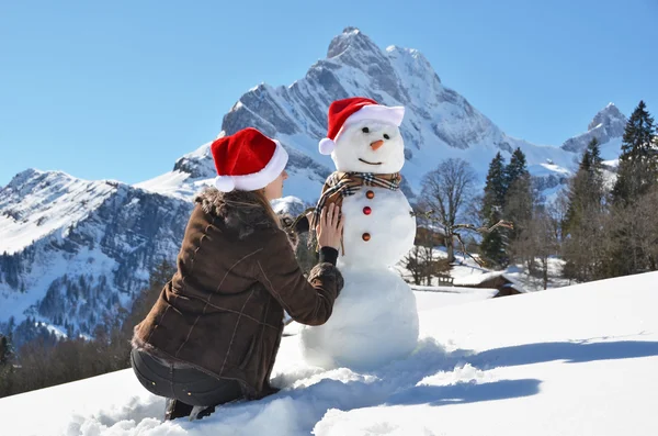 Menina com um boneco de neve — Fotografia de Stock