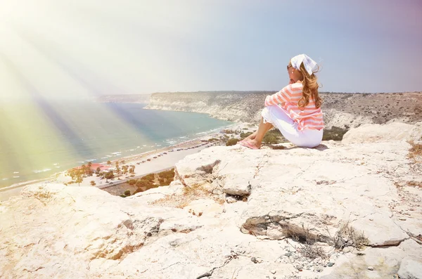 Jenta på klippen som ser ut mot havet. Kypros – stockfoto