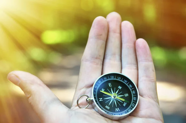 Compass in  hand against wood — Stock Photo, Image
