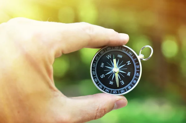 Compass in  hand against wood — Stock Photo, Image