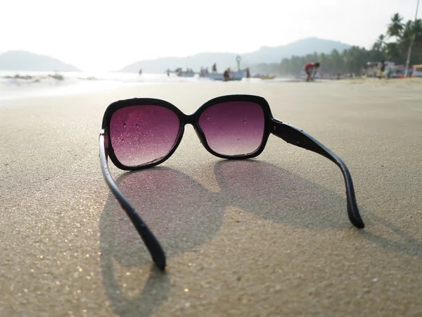 Sluneční brýle na písku Palolem Beach. — Stock fotografie
