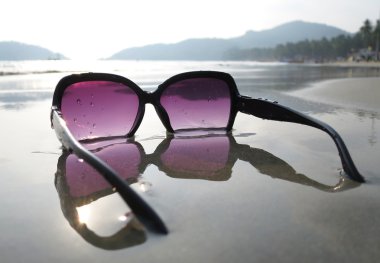Sunglasses on  Palolem beach. clipart
