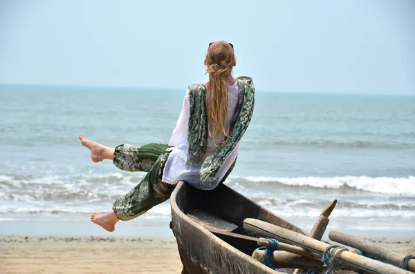 Fille assise sur un vieux bateau de pêche . — Photo