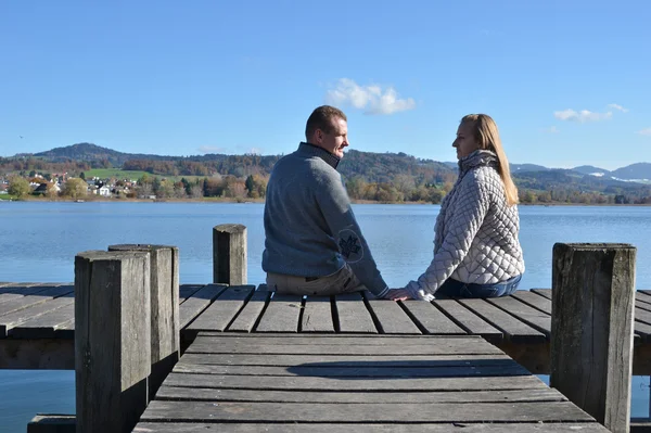 Couple on  wooden jetty at  lake — Stock Photo, Image