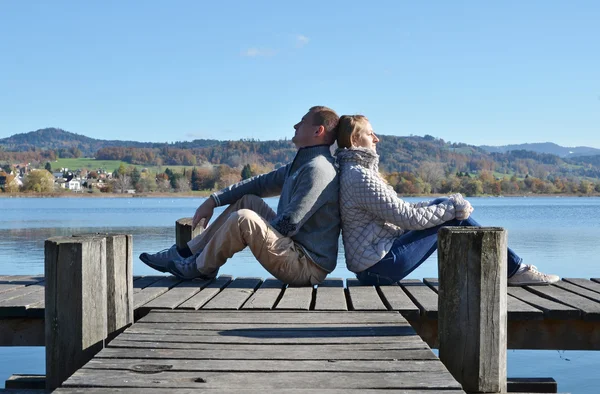 Couple on  wooden jetty at  lake — Stock Photo, Image