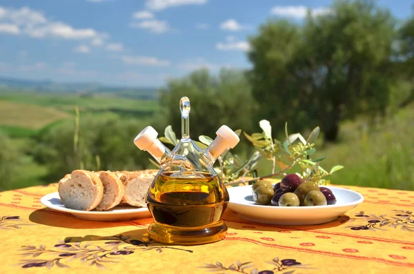 Olive oil and olives on the wooden table — Stock Photo, Image