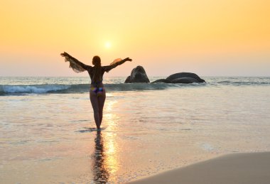 Genç kadın Agonda Sahilde meditasyon.