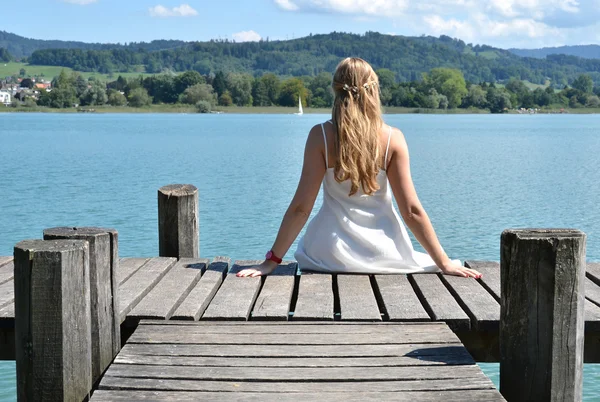 Meisje op de houten steiger. — Stockfoto