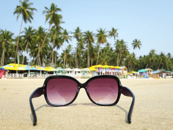 Sunglasses on the sand of Palolem beach. — Stock Photo, Image