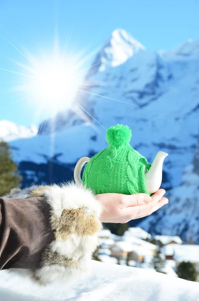 Tea pot in the knotted cap in the hand — Stock Photo, Image