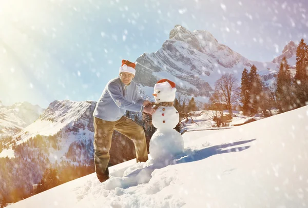 Adam bir Noel Baba şapkası ve kardan adam — Stok fotoğraf