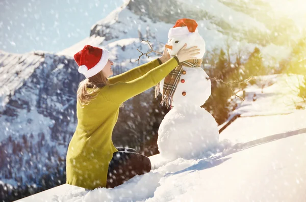 Ragazza decorare un pupazzo di neve — Foto Stock