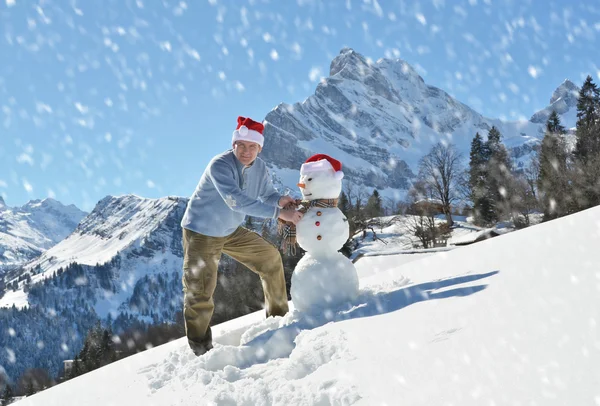 Ο άνθρωπος σε ένα καπέλο Santa και χιονάνθρωπος — Φωτογραφία Αρχείου