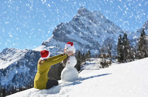 Tjej dekorera en snögubbe — Stockfoto