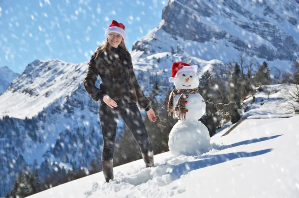 Menina decorando um boneco de neve — Fotografia de Stock
