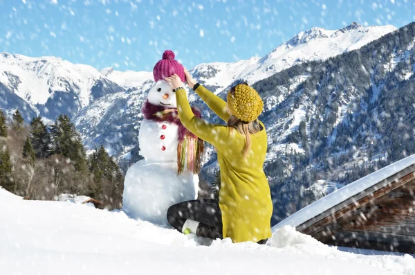 Ragazza decorare un pupazzo di neve — Foto Stock