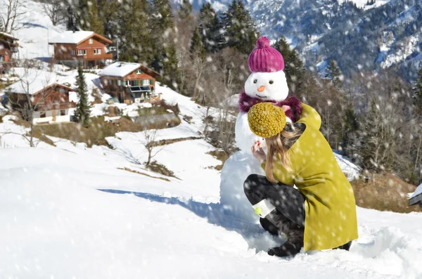 Chica decorando un muñeco de nieve — Foto de Stock