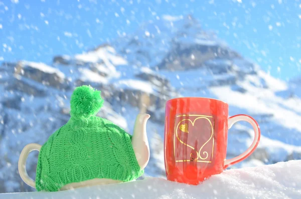 Tea pot in the knitted cap and cup — Stock Photo, Image