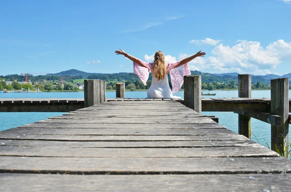 Girl on wooden jetty at lake — Stock Photo, Image