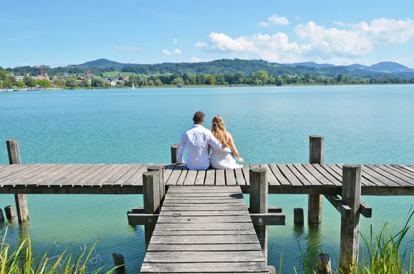 Couple on wooden jetty — Stock Photo, Image