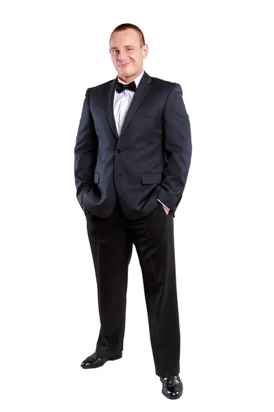 Junger Geschäftsmann im Anzug vor weißem Hintergrund lächelt. — Stockfoto