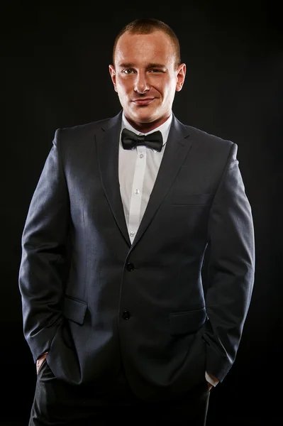 Portrait of handsome stylish man in elegant black suit. — Stock Photo, Image