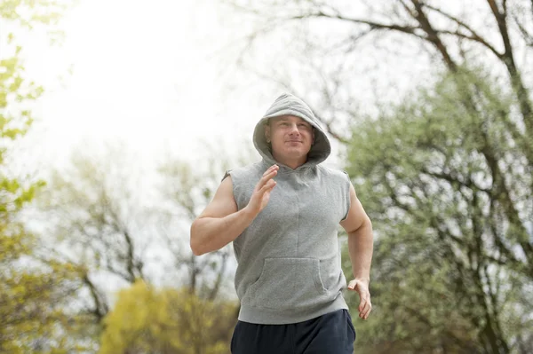 Un uomo attivo che fa jogging nel parco. Corsa in forma . — Foto Stock