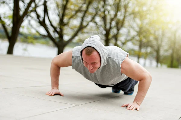 Uomo attivo che fa push up nel parco . — Foto Stock