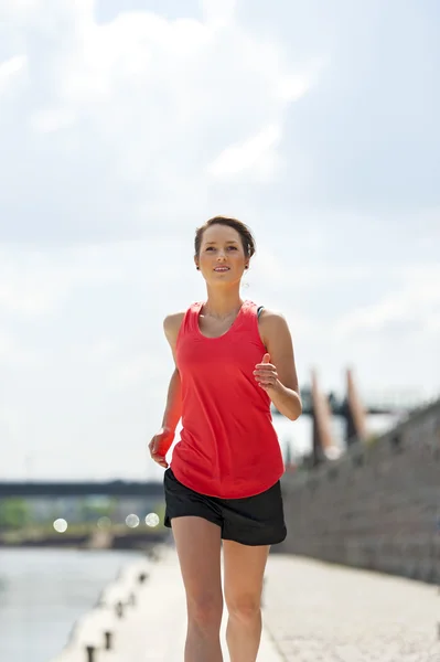 Fit vrouw joggen door de rivier. — Stockfoto