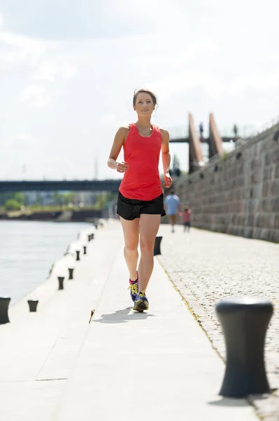 Dopasuj kobieta jogging nad rzeką. — Zdjęcie stockowe