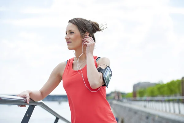 Fitte Joggerin ruht sich nach Lauf aus und hört Musik. — Stockfoto