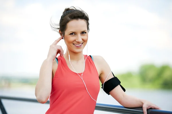 Ajuste mujer jogger descansando después de ejecutar escuchar música . — Foto de Stock