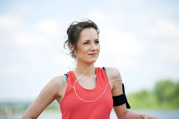 Ajuste mujer jogger descansando después de ejecutar escuchar música . —  Fotos de Stock