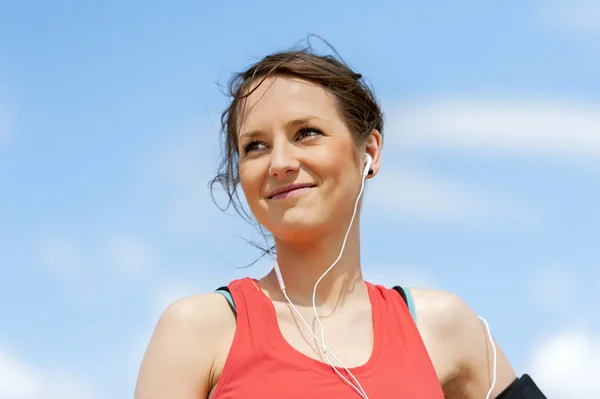 Fit vrouw jogger rust na uitvoering luisteren muziek. — Stockfoto